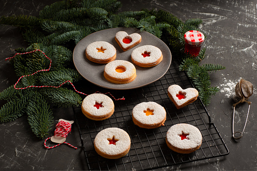 Linzer cookies served on a plate decorated with spruce branches. High quality photo