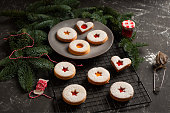 Linzer cookies served on a plate decorated with spruce branches