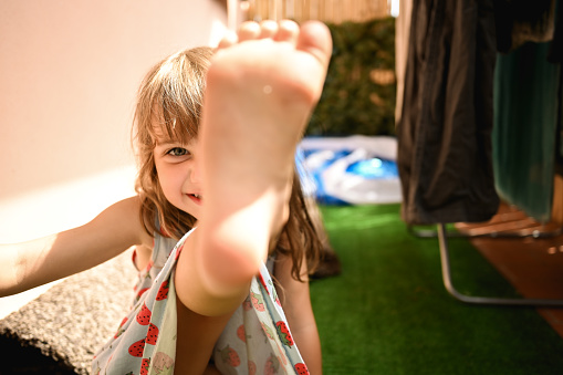 little girl barefoot having fun on a home terrace.