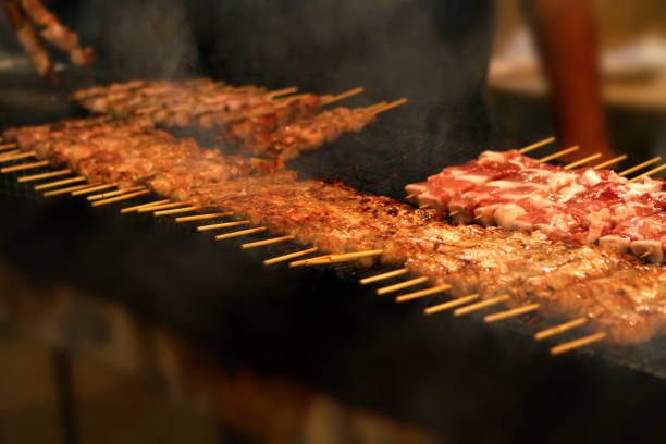 Preparing  many Greek souvlakia - pork meat on barbecue in a traditional event