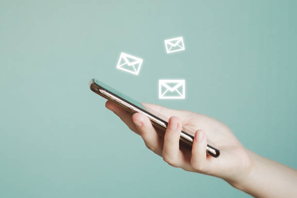 istock Hand holding mobile smartphone and email icon to send or receive mail online on web. Communication and Technology concept. 1442033993