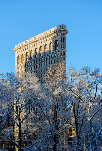 A snowy morning at Madison Square Park and Flatiron Building seen on the background. Midtown Manhattan, NY, USA