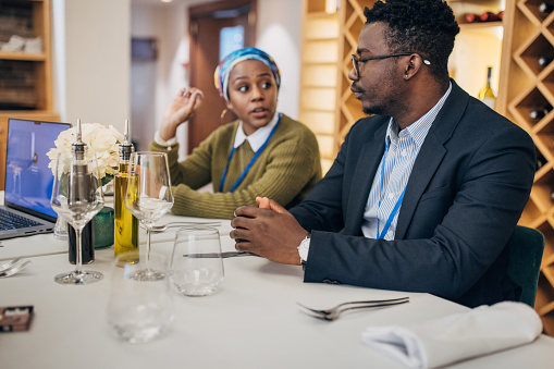 Diverse people, male and female business people together on lunch in luxury restaurant.