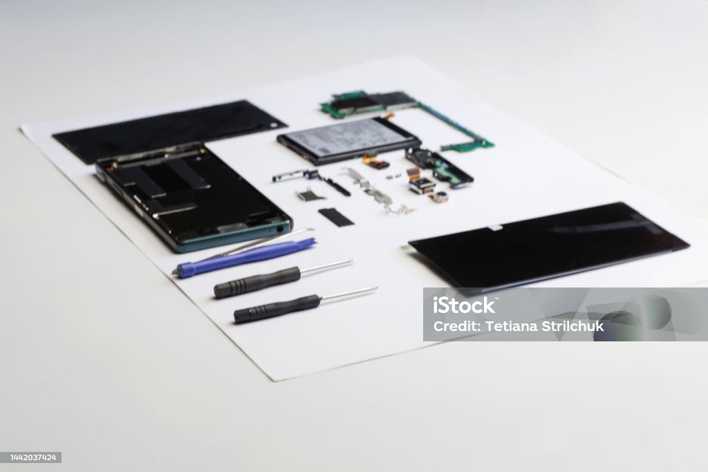 Defocus electronic repair. Technician repairing electronic circu Defocus electronic repair. Technician repairing electronic circuit board with soldering iron. Engineer disassembling components broken smartphone and take off logic board. Out of focus. Mobile Phone Stock Photo