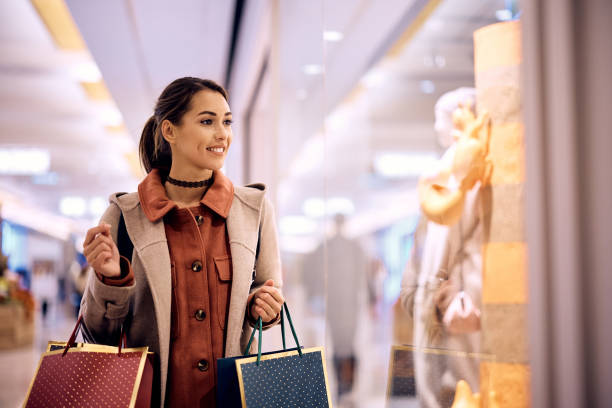 istock Young woman looking at store windows while shopping in the mall. 1442038206