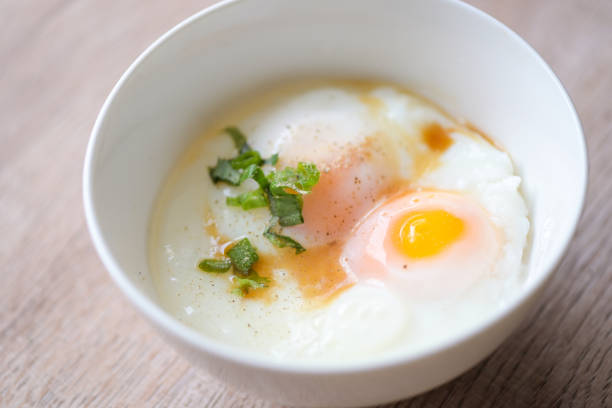 istock egg breakfast , soft-boiled eggs on white bowl with pepper, coriander on wooden table, Onsen tamago egg - egg microwave 1442038505