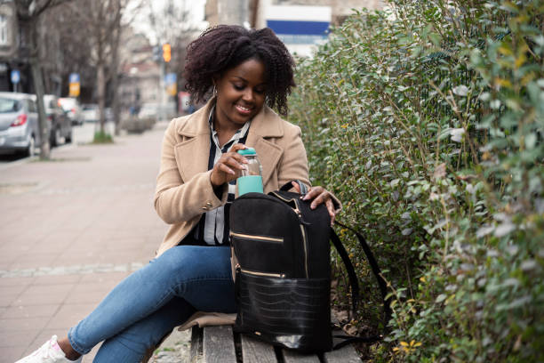 Portrait of a beautiful, happy Afro girl taking a break on the street stock photo