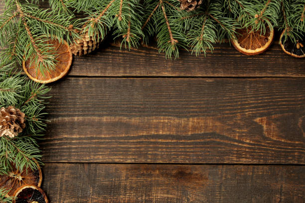 istock Christmas and New Year frame for text with Christmas tree and pine cones and dried oranges on brown background. view from above. 1442040050