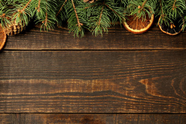istock Christmas and New Year frame for text with Christmas tree and pine cones and dried oranges on brown background. view from above. 1442040054