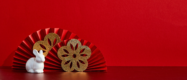 Happy Chinese New Year banner template. Red paper fans with golden flowers and white rabbit decoration on red background