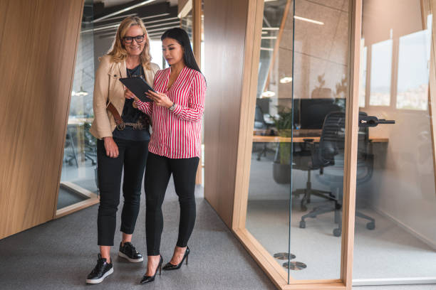 istock Mixed Race Female Coworkers Discussing At Work With A Digital Tablet 1442041329