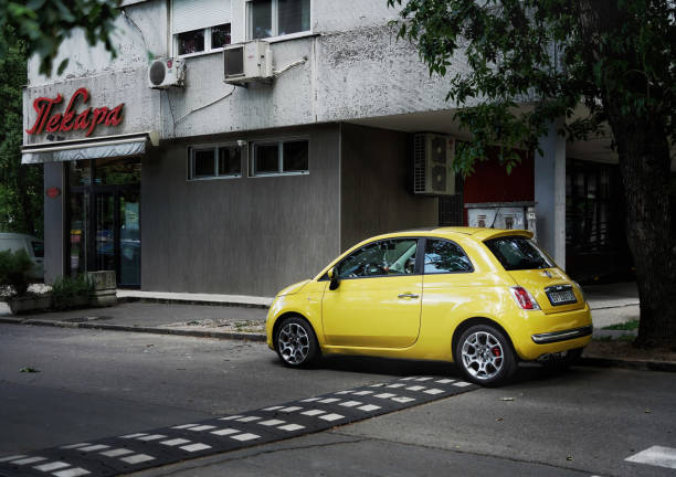 ładny żółty fiat 500 cinquecento (2 generacji, 2007) jest zaparkowany w dzielnicy novi beograd. - cinquecento zdjęcia i obrazy z banku zdjęć