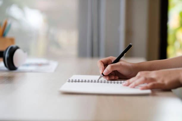 istock Close up of woman studying, reading book, and taking notes. 1442064696