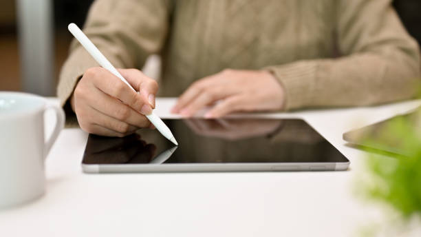 istock Woman in cozy sweater using stylus pen, drawing or writing on tablet screen, using digital tablet 1442066463