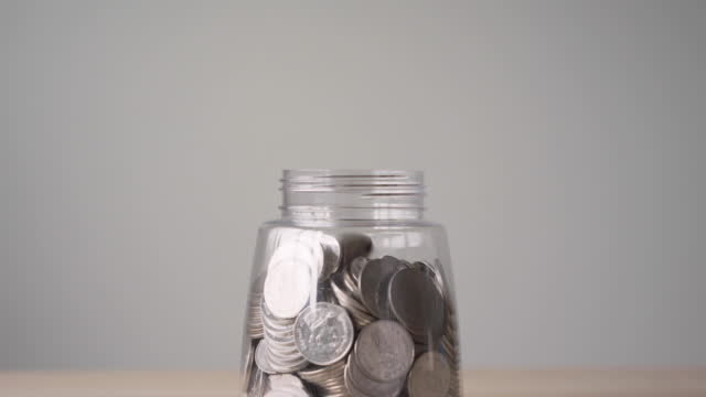 Coins falling into a jar. Money savings for retirement, education, pension concept