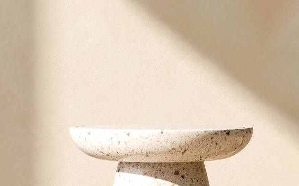 istock Modern and minimal round white granite pedestal table podium with sunlight and shadow on beige brown wall 1442077270