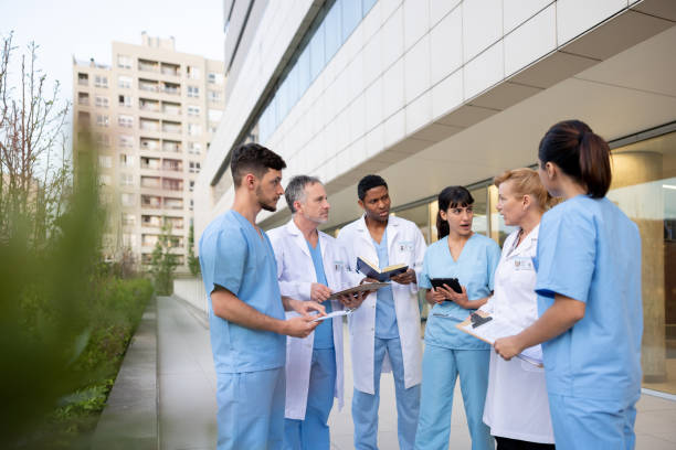 группа медицинских работников беседует за пределами больницы - civilian стоковые фото и изображения