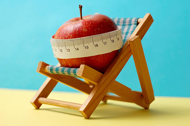 Apple with measuring tape on deckchair stock photo