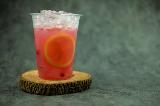 istock Pink lemonade with ice and lemon slices in a plastic glass. 1442079919