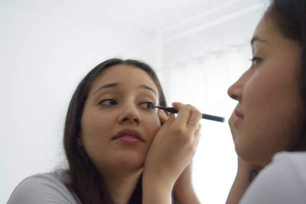 Young girl performing makeup on her face
