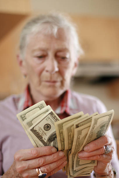 istock Senior woman counting savings money 144208166