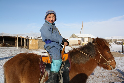 A child rides a Takhi horse, Tuv region, Mongolia. The nomadic children begin to ride the horses when they are 3-5 years old.