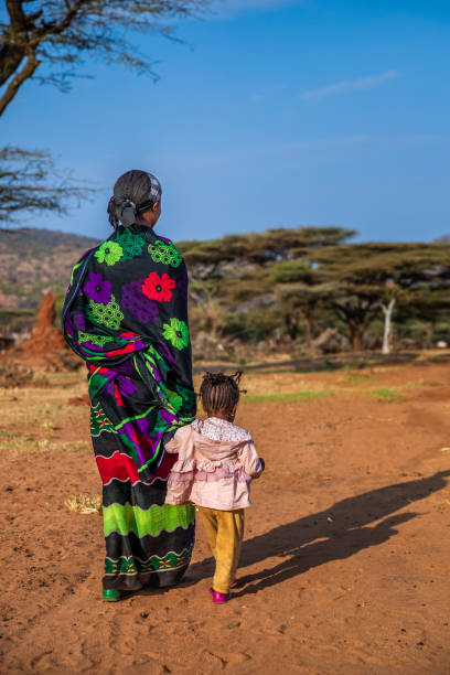 mulher da tribo borana caminhando com seu bebê, etiópia, áfrica - women indigenous culture africa ethiopia - fotografias e filmes do acervo