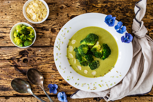 Cream broccoli soup on wooden table