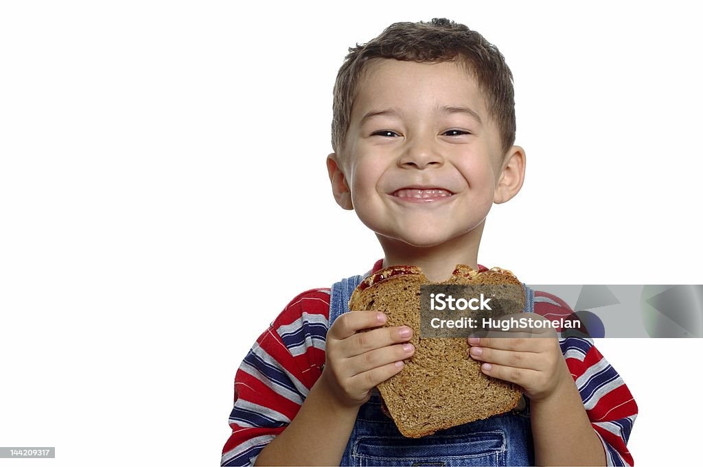 Menino com sanduíche de pasta de amendoim e geleia no pão integral - Foto de stock de Criança royalty-free