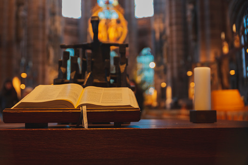A closeup shot of an open Bible on a stand inside a Church