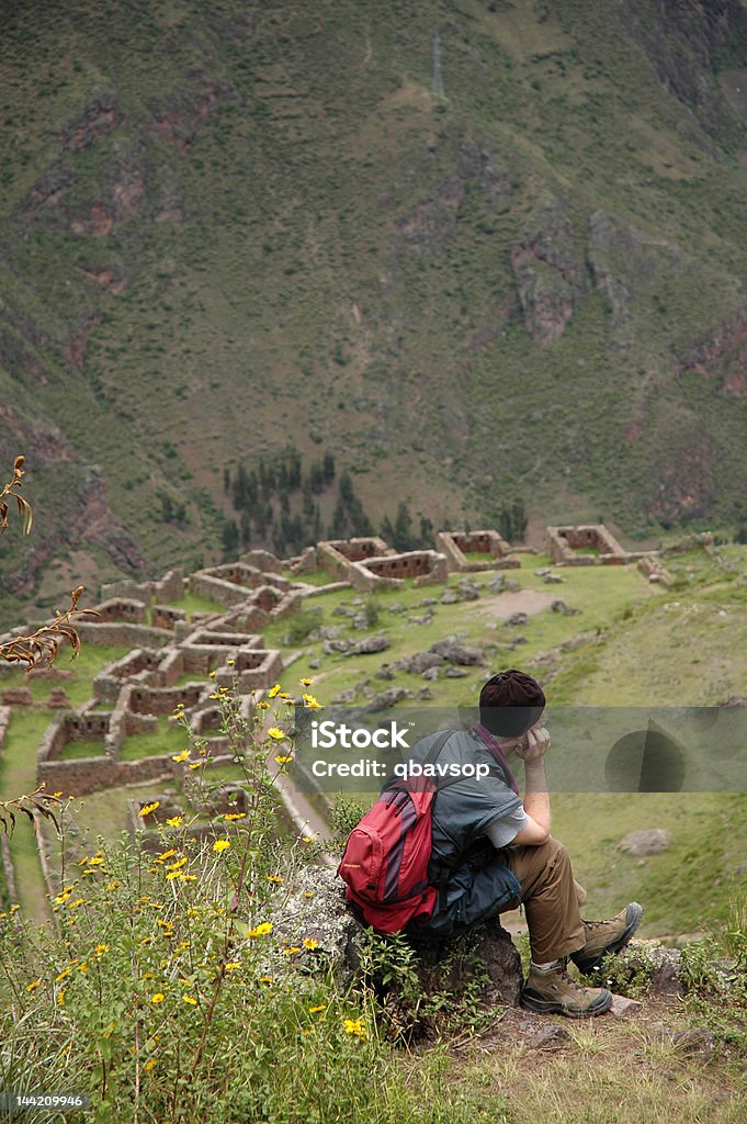 Man sitting over the Inca ruins Trekker taking rest over the Inca ruins, Cuzco, Peru Adult Stock Photo