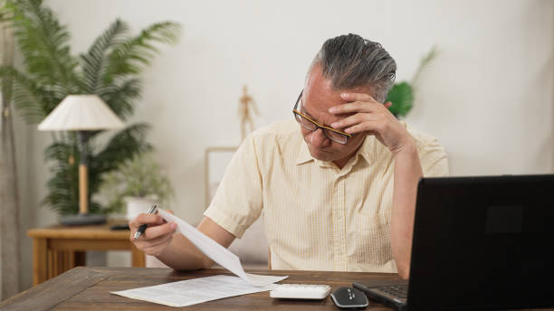 istock Senior man working with laptop at home. male model sitting at the dinner table and doing his homework or surfing in internet. he seems to meet the problem working from home online 1442100113
