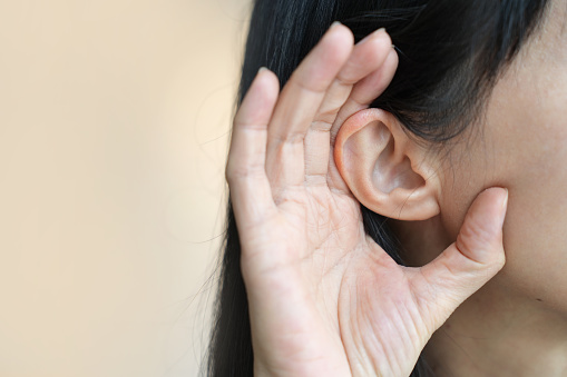 Asian woman with hearing difficulties close up, hearing loss