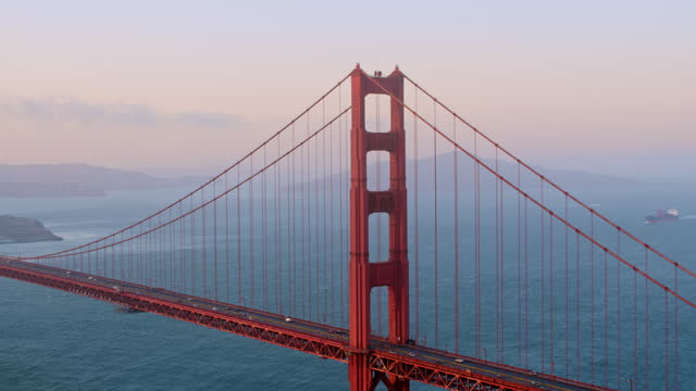 AERIAL Golden Gate Bridge in San Francisco, CA with view of the city at sunset