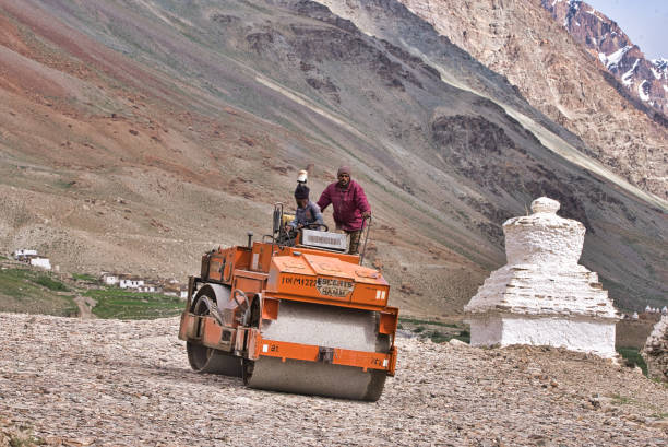 A Border Roads Organisation crew manoeuvres a road roller in the inner Himalayas Ladakh region stock photo