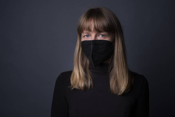 istock Blonde female in a black protective face mask with a sad tired expression 1442102216