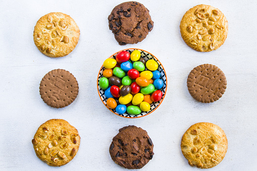 Different cookies and chocolate candy balls on a white background