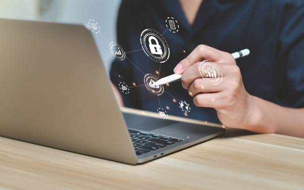 istock Human sitting in front of laptop with floating data safety icons 1442102871