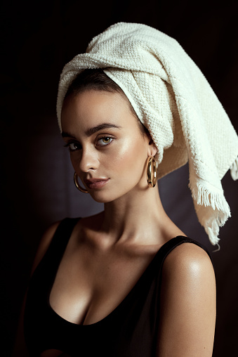 Portrait of a young woman in a swimsuit, wearing a towel, hat, or headband on her head