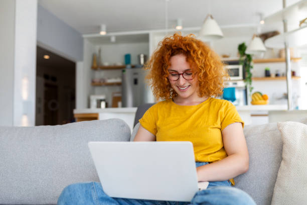 istock Woman sitting with computer on sofa, studying at home, e-learning and remote freelance job concept 1442105895