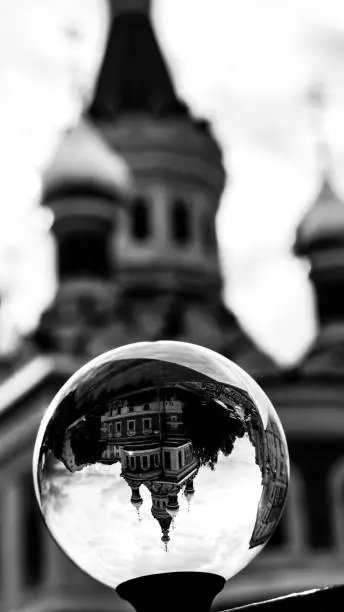 A greyscale shot of church reflected on a small iceball