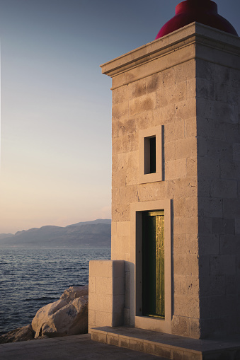 A vertical shot of the Postira Lighthouse surrounded by the sea in Croatia