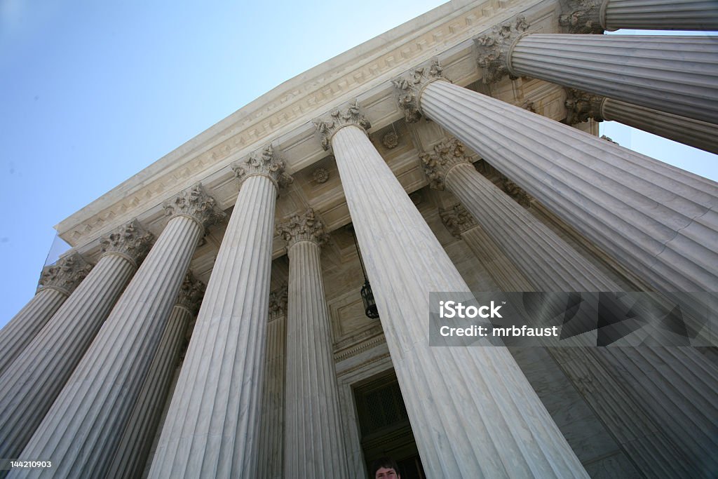 The tall pillars of the US Supreme Court building Looking up at the Supreme Court on a sunny day. Legal System Stock Photo