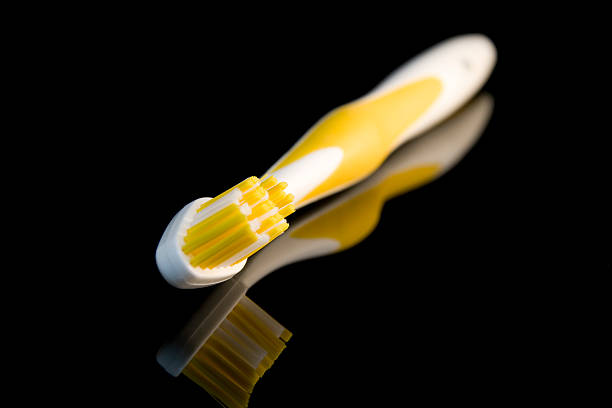 Yellow Toothbrush on Black Reflection stock photo