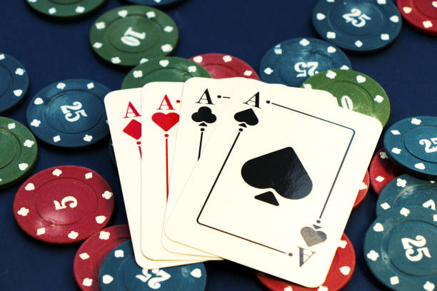 istock Closeup shot of four aces and different chips spread on a poker table 1442110266