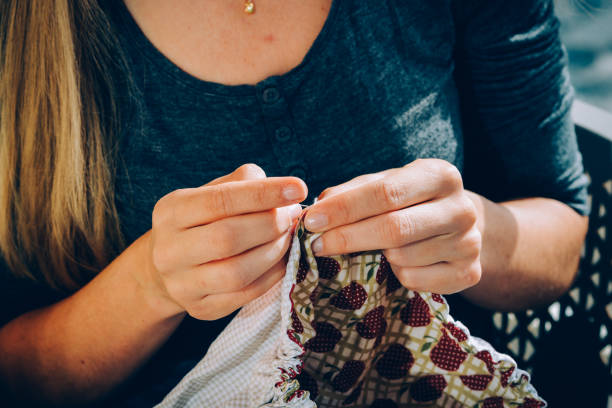 istock Woman tailor with thread in a needle sewing cloth 1442110982