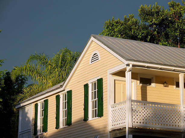 Wooden beige house and storm at sunset