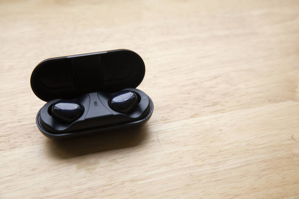 istock Top view of wireless earbuds on a wooden surface - copy space 1442111763
