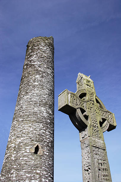 istock Irish Cross in front of a Monastic round tower 144211207