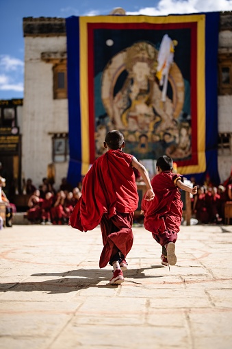 Lo Manthang, Nepal – May 28, 2022: A back view of young Tibetan Buddhist Monks at the ancient Tiji Festival in walled city of Lo Manthang